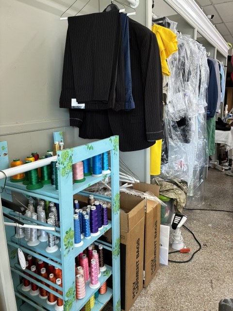Formal wear and alterations on the rack — garment bags ready